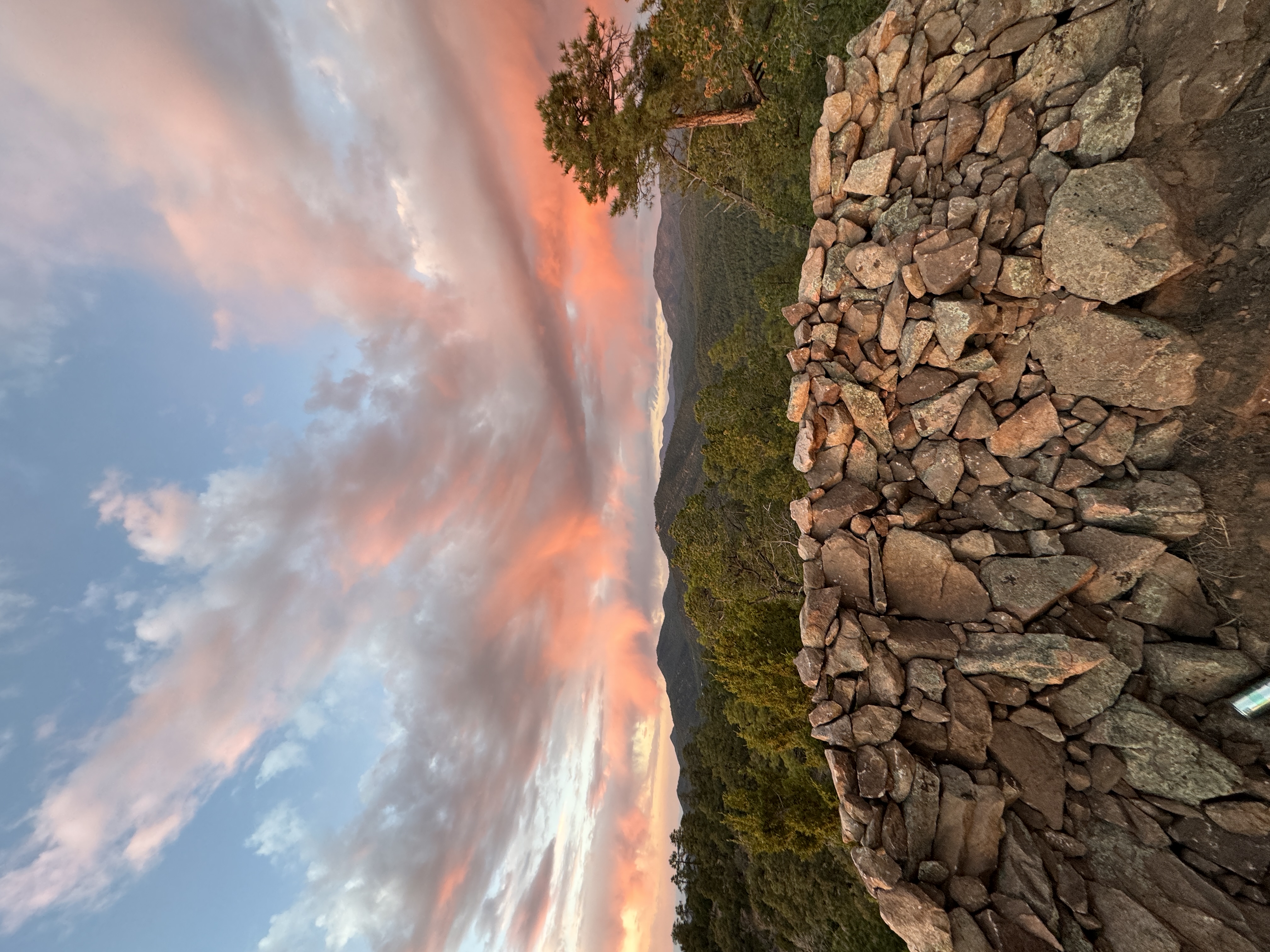 Stone wall and sunset — pink clouds over Sangre de Cristos